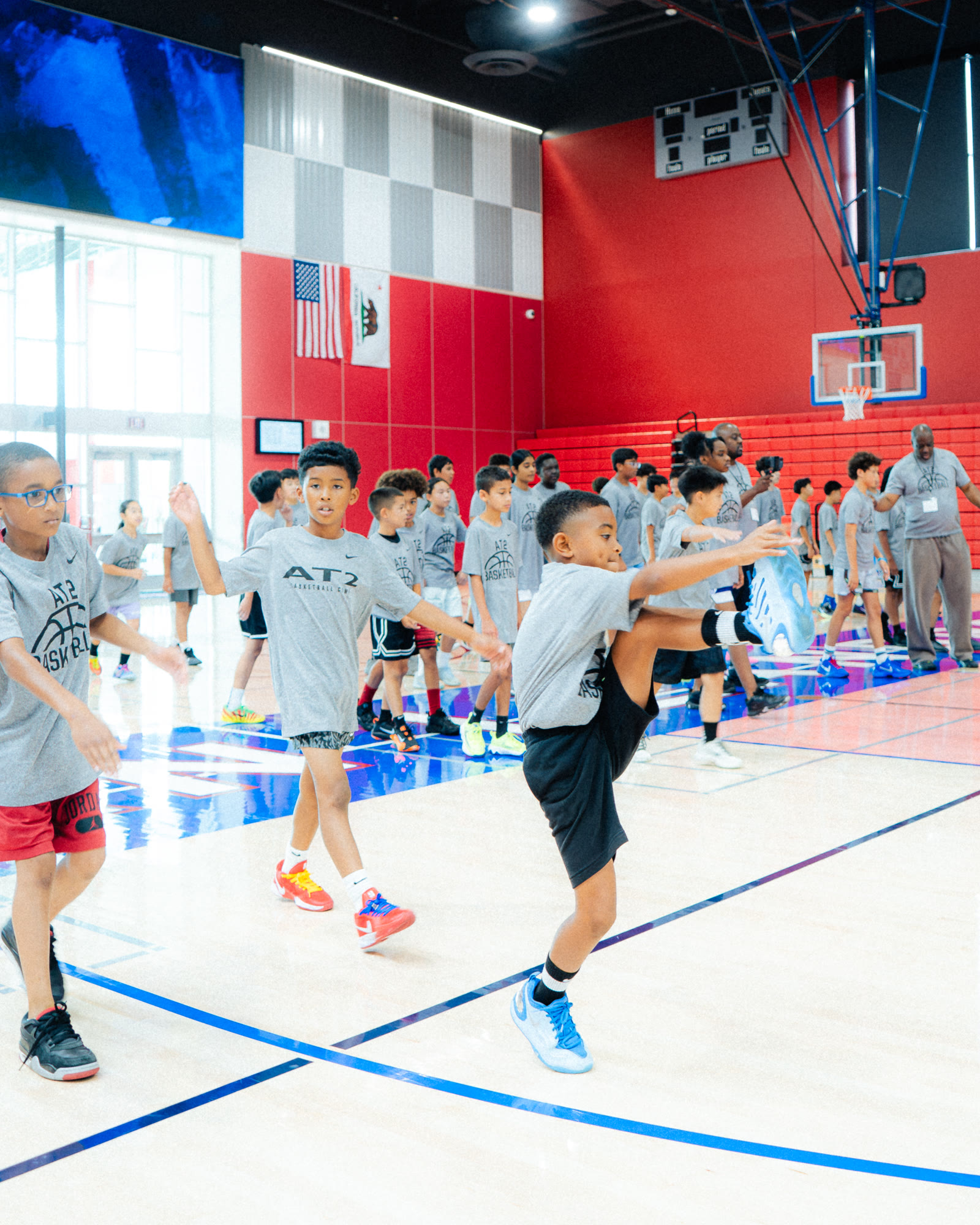 Campers in AT2 shirts warming up across the court