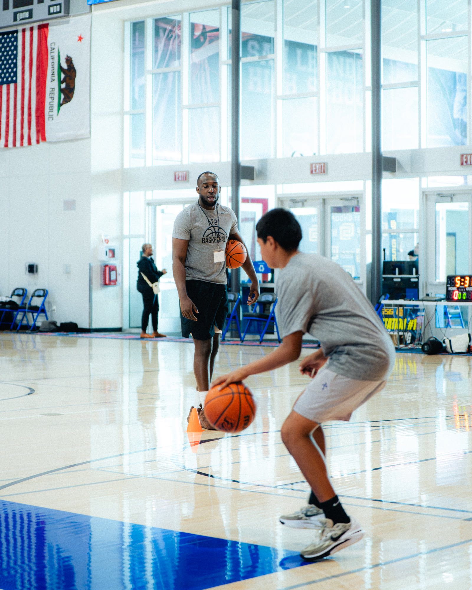 An AT2 coach guiding a player through a ball-handling station