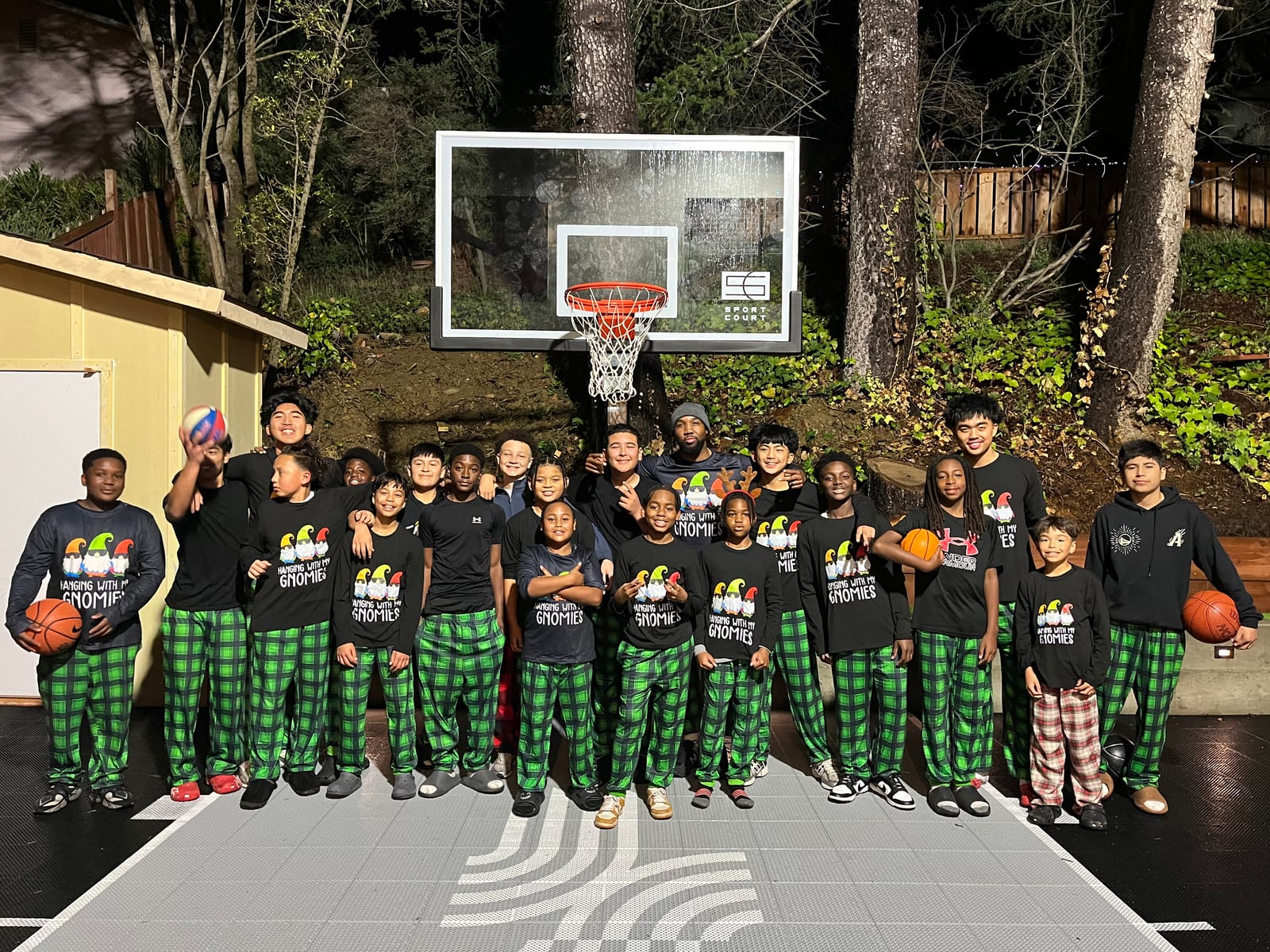 The JustHoop community — players and coaches together on the outdoor court in matching holiday pajamas