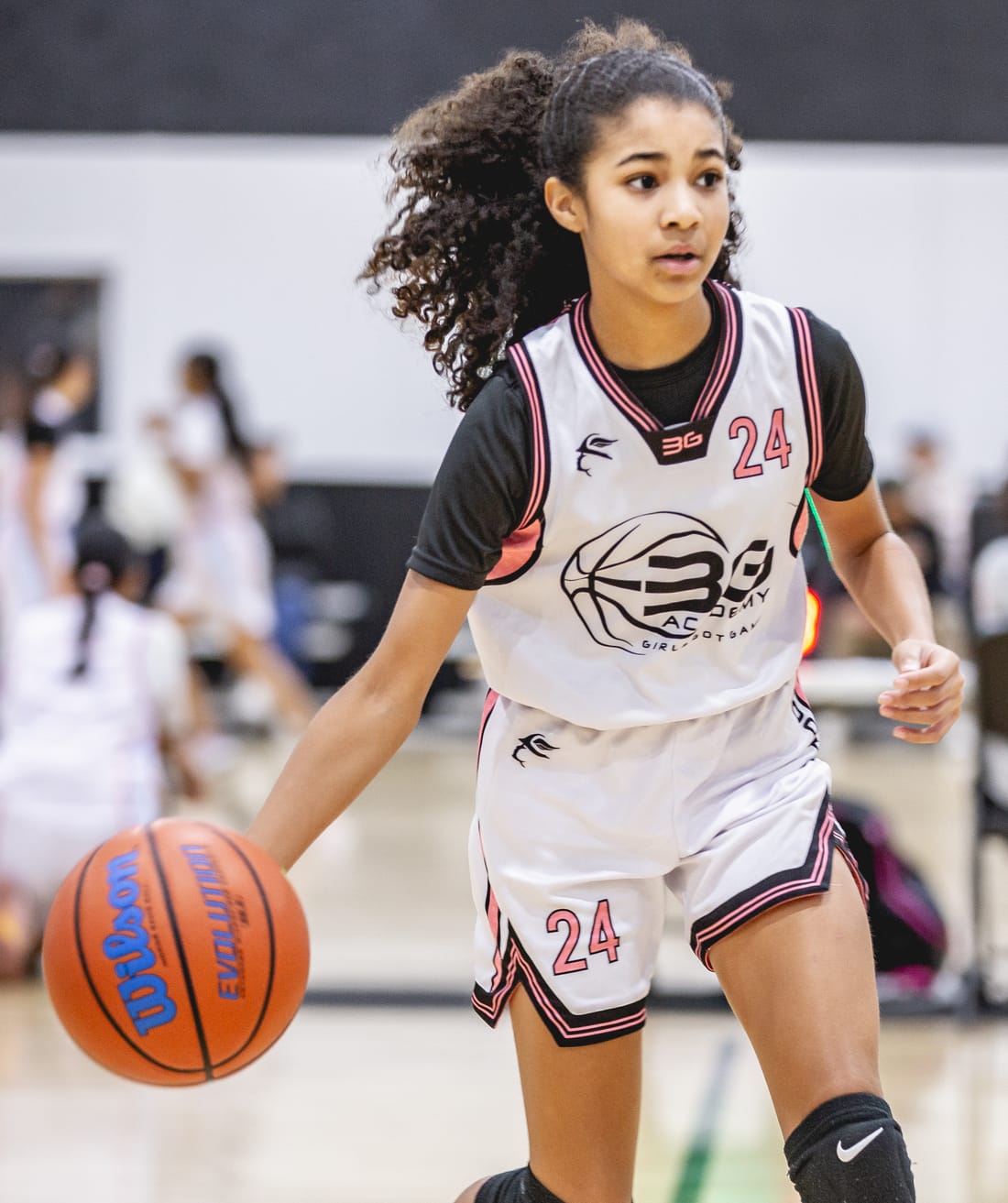 A young Just Hoop athlete driving with the ball in a game